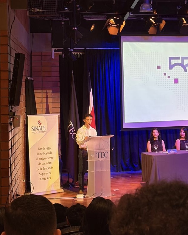 Estudiante de ATI en el podio durante la ceremonia de acreditación SINAES en el TEC